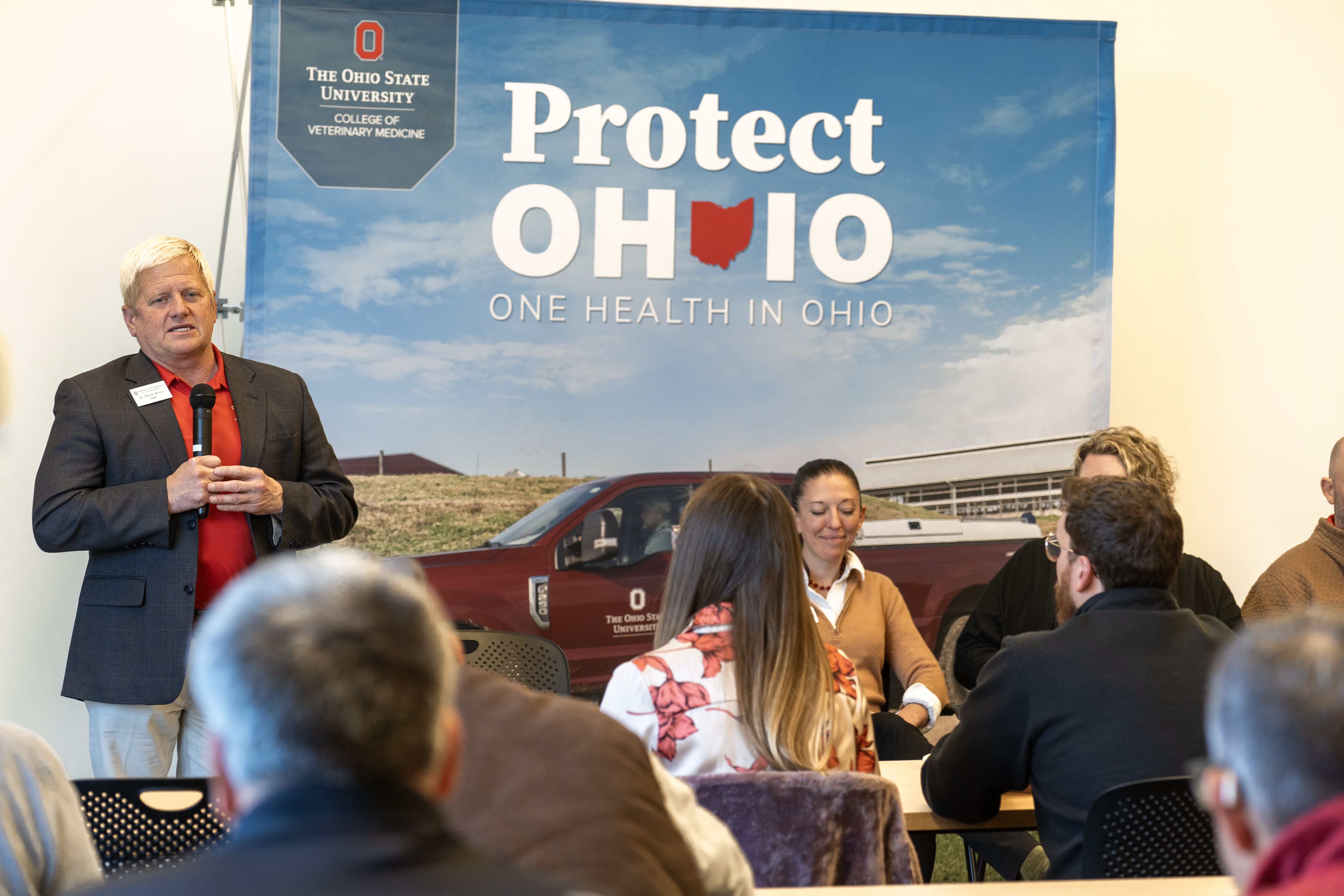 Dean Rustin Moore speaks into a microphone to the audience