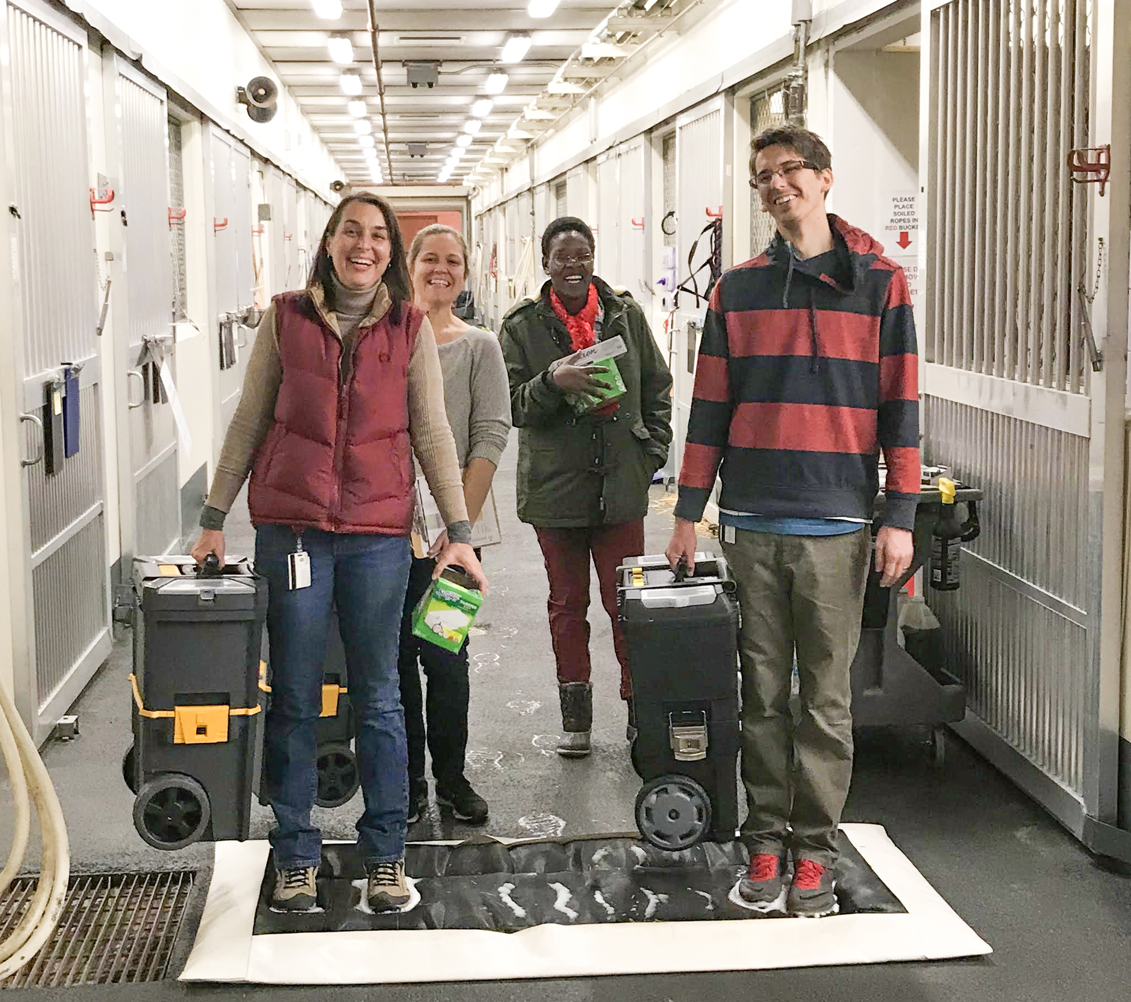 Dr. Feyes smiles with a group carrying supplies