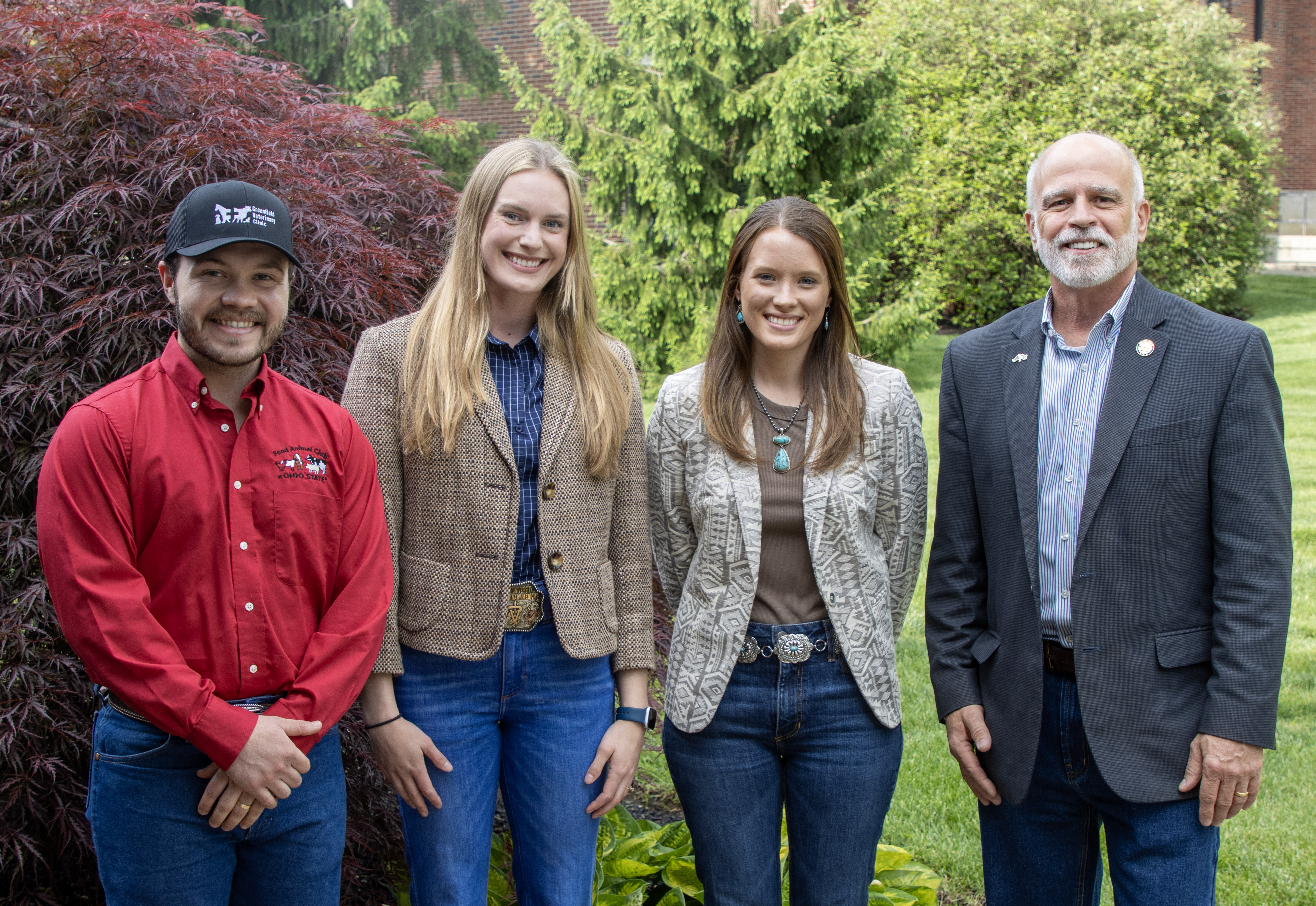 group of four people stand together for a photo