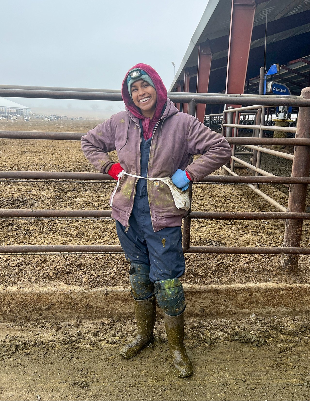 Dr. Oruganti smiles for a photo on a farm
