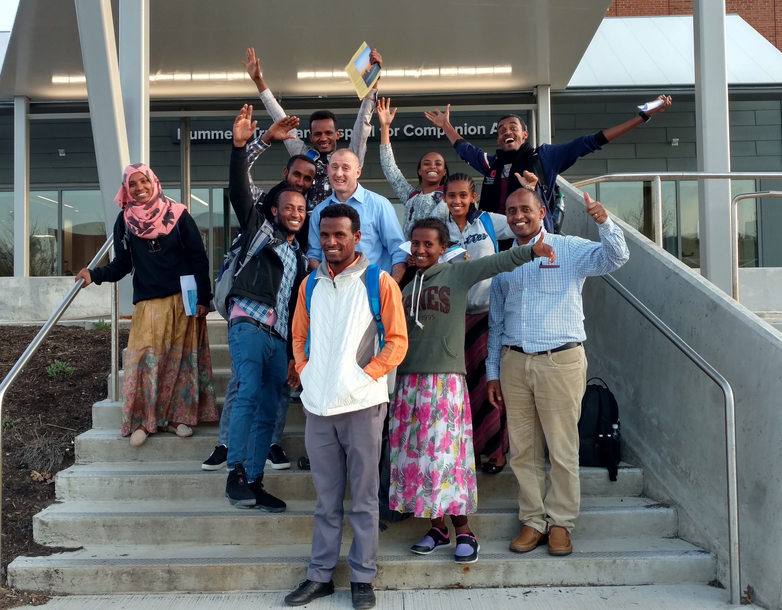 A group with Dr. Coniglio posing for a photo on a stairway