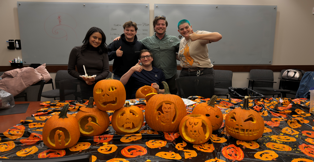 group of students in front of halloween jack o lanters