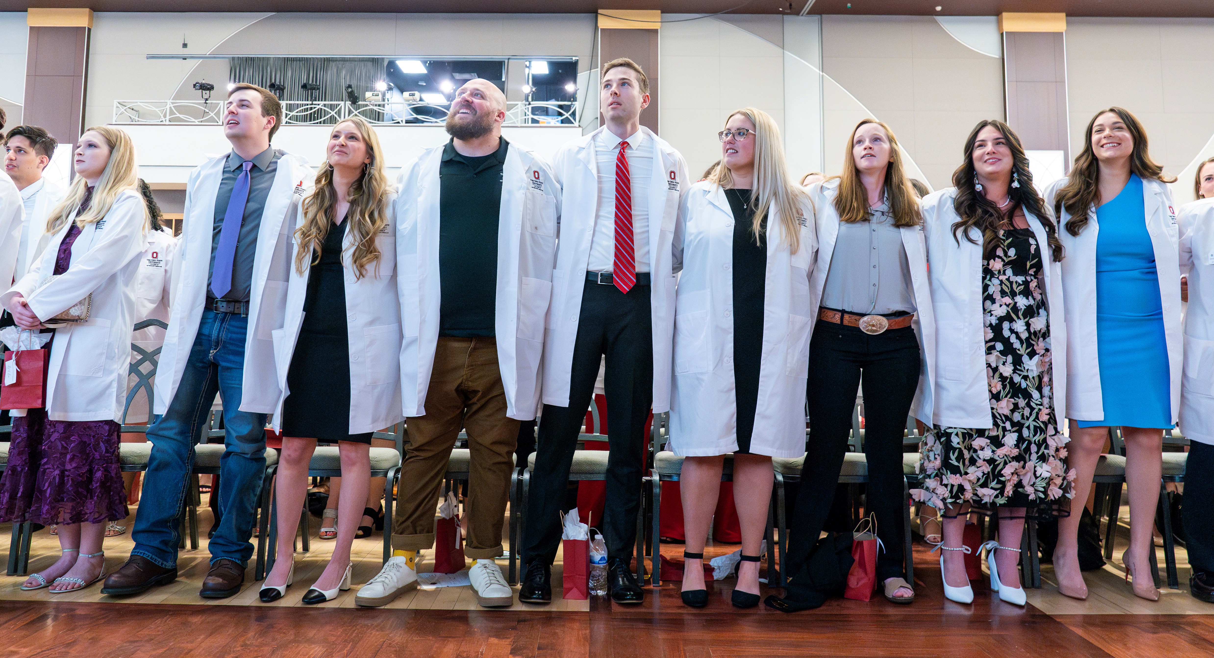 group of students at white coat ceremony, singing carmen ohio