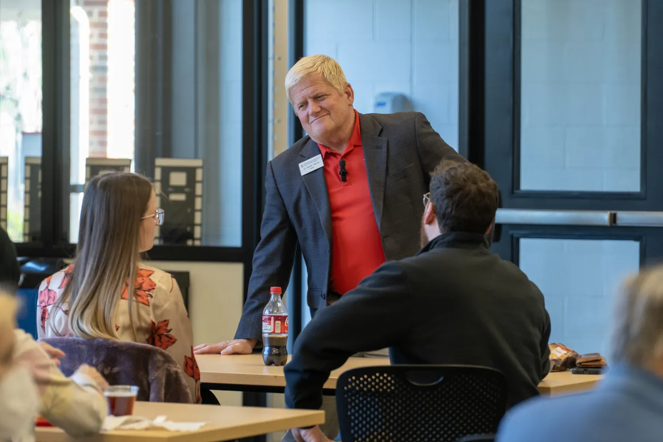 Dean Rustin Moore stands and chats with two students
