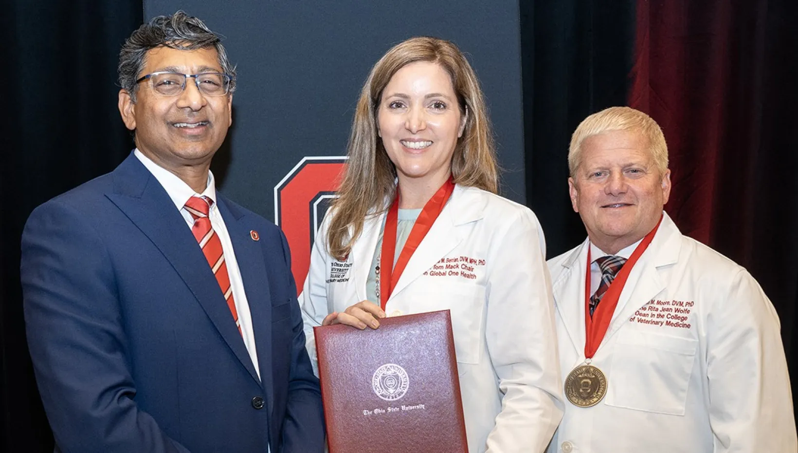 Dr. Ravi V. Bellamkonda, president of The Ohio State University (left) and Dr. Rustin  Moore, dean of Ohio State’s College of Veterinary Medicine  (right), with Dr. Amanda Berrian (center) at the college’s endowed chair ceremony.