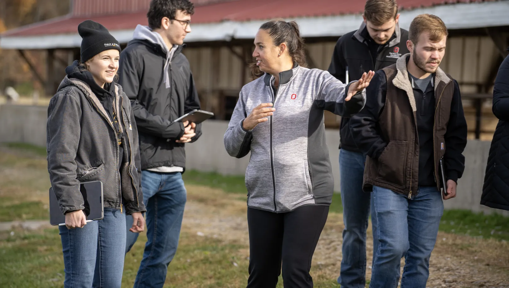 instructor with students on cow farm