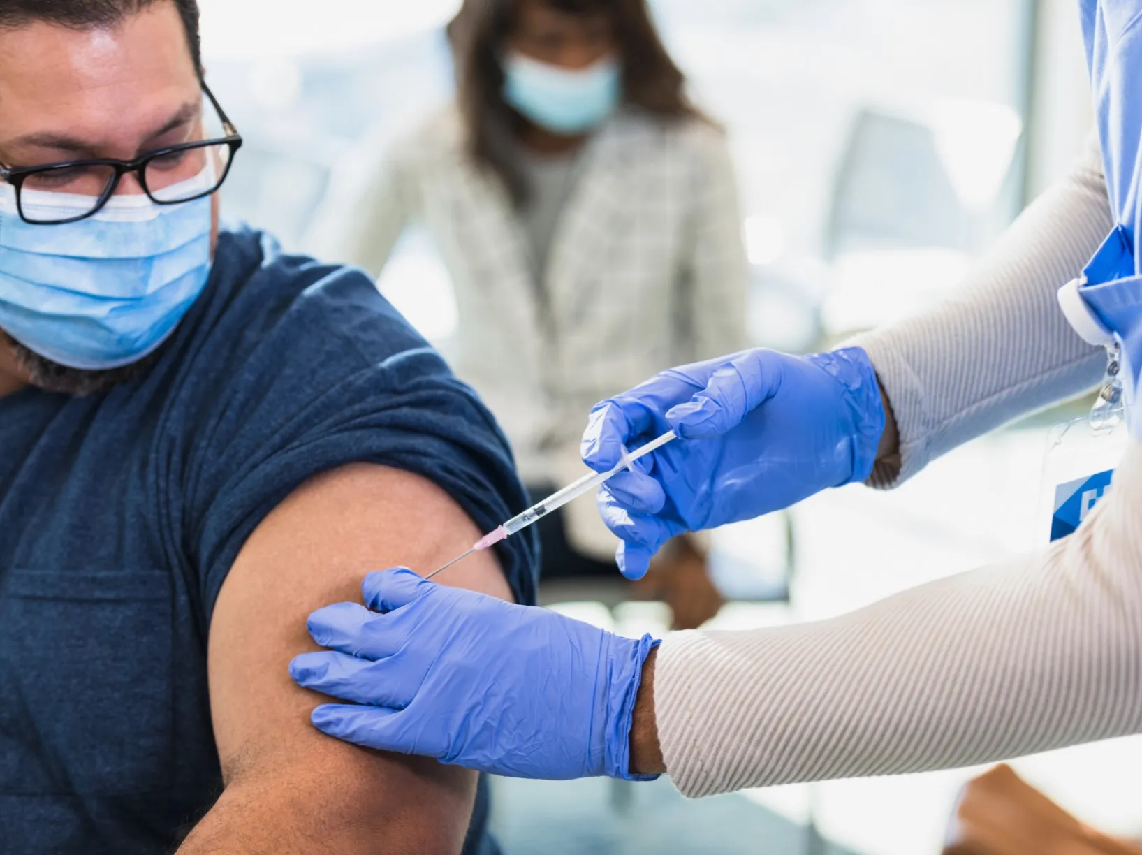 Man receiving a shot from a physician