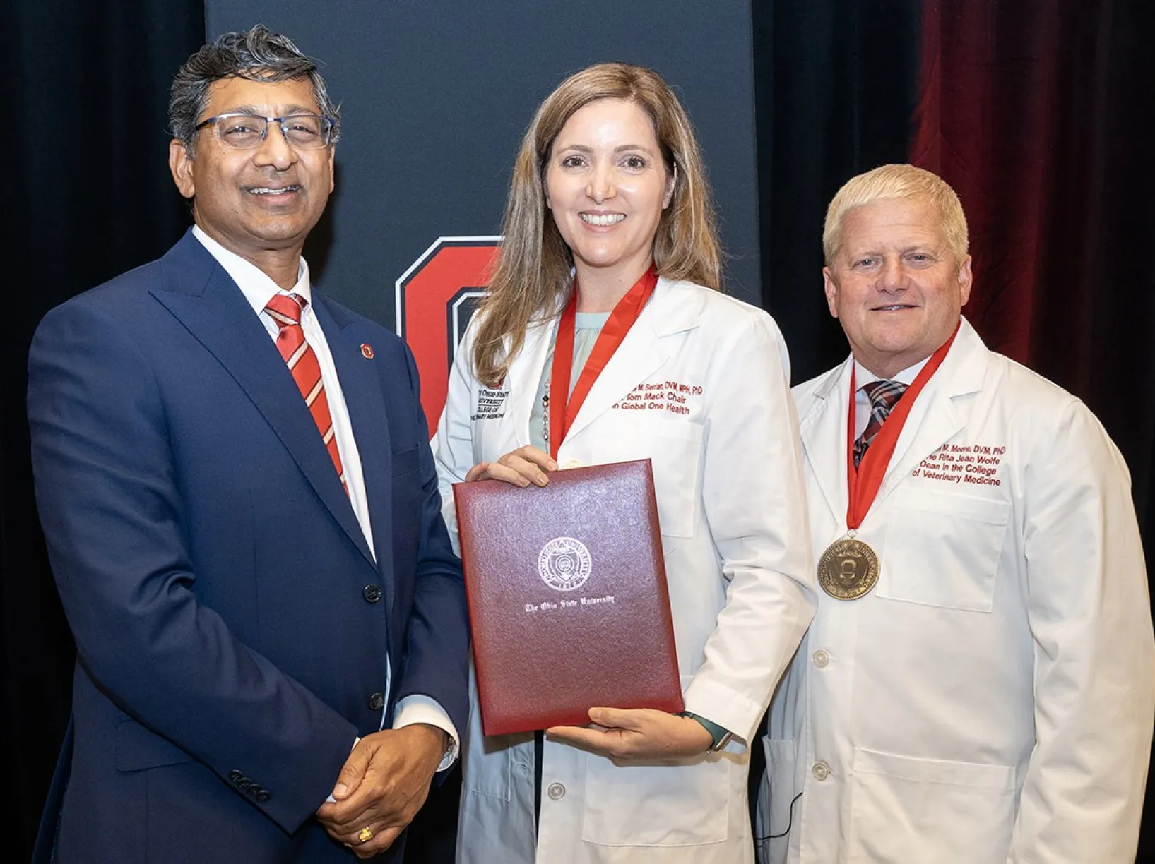 Dr. Ravi V. Bellamkonda, president of The Ohio State University (left) and Dr. Rustin  Moore, dean of Ohio State’s College of Veterinary Medicine  (right), with Dr. Amanda Berrian (center) at the college’s endowed chair ceremony.