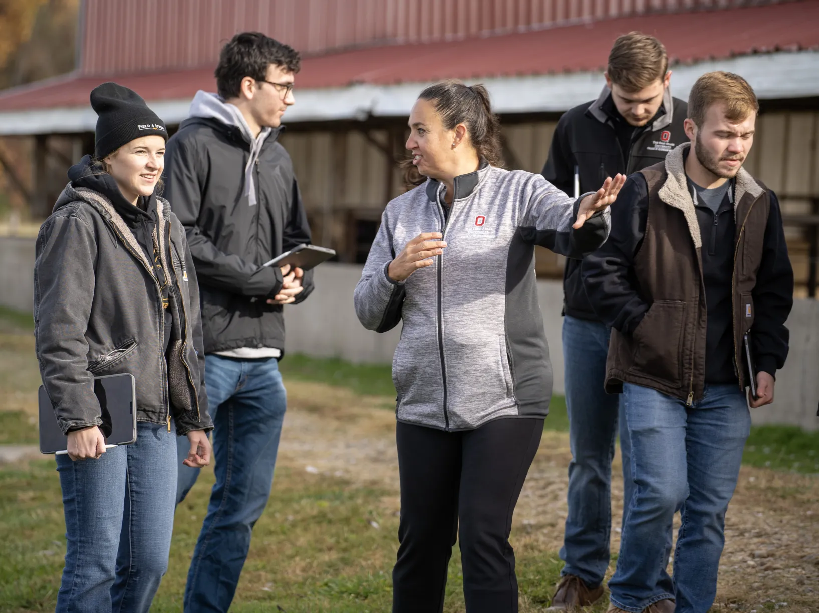 instructor with students on cow farm