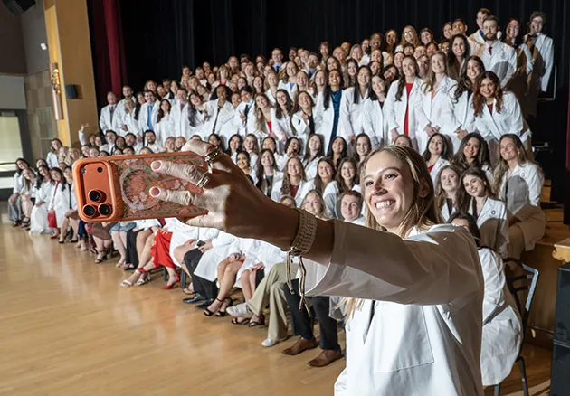 Photo of veterinary student taking a selfie of the whole class at the 2026 white coat ceremony