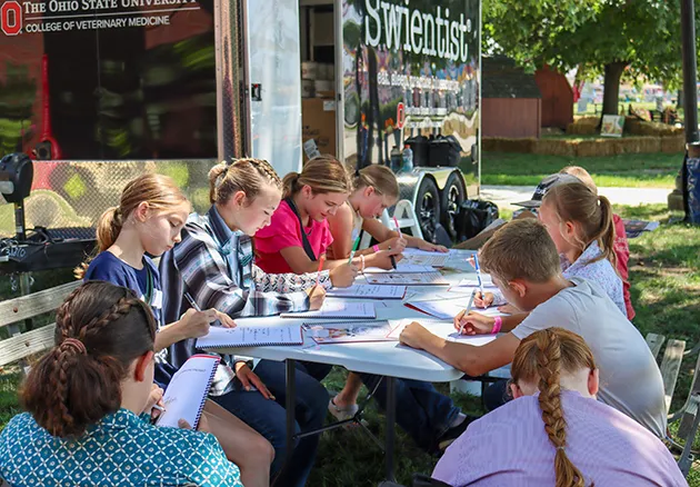 Young child coloring at the table for the Swientist program at the Ohio State Fair