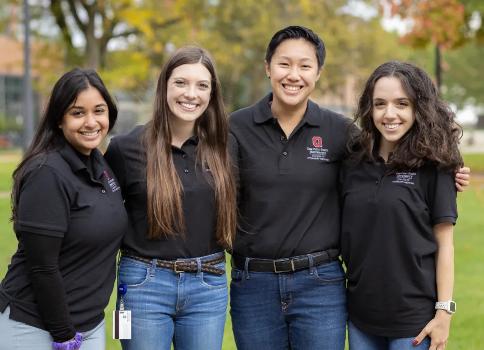 four veterinary students standing outside