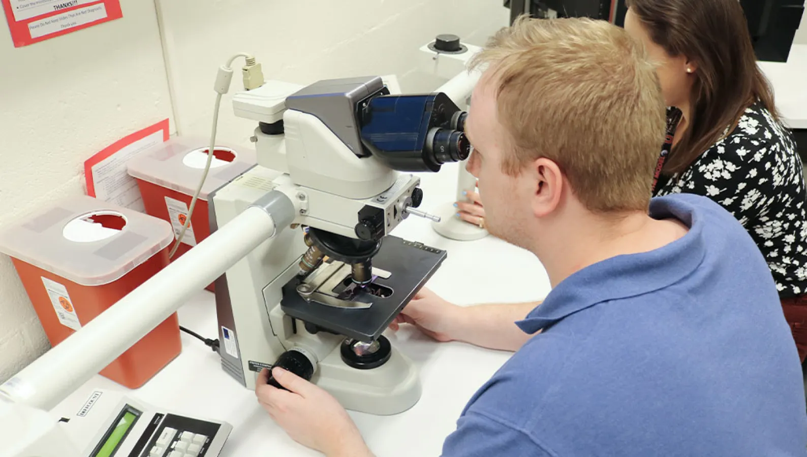 a man looking into a microscope
