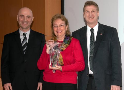 Dr. Anna Marie Skalka (center) receives Career Award crystal from Center for Retrovirus Research Director Dr. Patrick L. Green (right) and Center member Dr. Mamuka Kvaratskhelia (left).