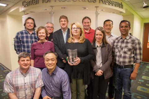 Dr. Daria Hazuda with CRR members. Shown from left are (kneeling) Jesse Kwiek, Sanggu Kim, (standing) Michael Oglesbee, Karin Musier-Forsyth, Lawrence Mathis, Patrick Green, Daria Hazuda, Ross Larue, Kristine Yoder, Li Wu, Namal Liyanage