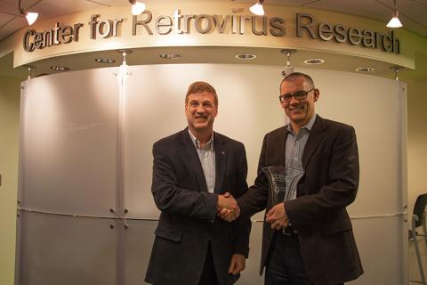 Dr. Paul Bieniasz (right) receives Career Award crystal from Center for Retrovirus Research Director Dr. Patrick L. Green (left).