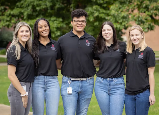 Five students posing and smiling 